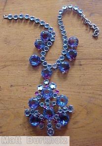 Schreiner single chain of faceted chaton with 7 drippy large faceted chaton dangling radial shield shaped pendant large faceted chaton center 6 large faceted chaton bicolor sapphire ruby ice blue jewelry