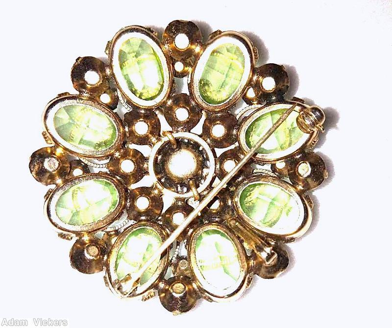 Schreiner 2 level 8 scrollwork radial pin large round chaton center 8 surrounding navette bottom 8 large oval stone 8 large round cab bicolor ruby green chaton center pink small chaton celery green large faceted oval stone brown metalic navette green navette goldtone jewelry
