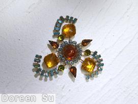 Schreiner 3 baguette branch sprawling radial pin round cab center 14 surrounding small stone 3 large faceted square stone 3 teardrop dragon breath gold fluss red round cab ice blue small clear chaton brown clear teardrop large topaz rose cut square nugget aqua clear small baguette peridot faceted small chaton goldtone jewelry