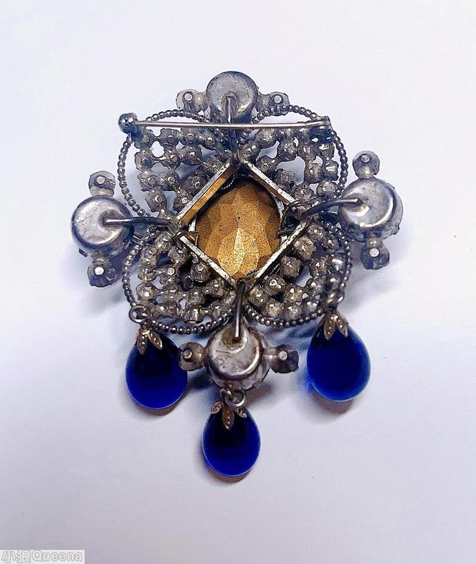 Schreiner 3 dangle top down pin large oval cab center top surrounding 3 round small stone in 4 wired pedal 4 large chaton large bicolor ruby navy faceted oval stone center royal blue goldtone jewelry
