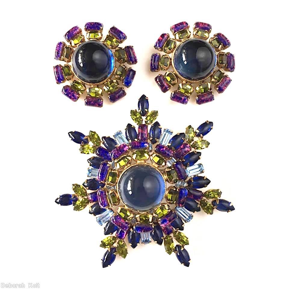 Schreiner 7 beam starburst pin large round cab center 10 surrounding small oval cab 10 surrounding baguette navy large round cab center peridot navy navette ice blue baguette pink marbled purple goldtone jewelry