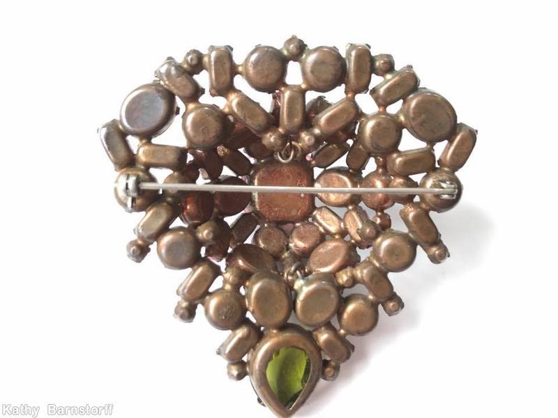 Schreiner domed triangle shaped pin large square stone center 1 large teardrop small baguette 4 surrounding small baguette 2 surrounding oval stone 4 surrounding chaton peridot faceted peach square crystal pink amber jewelry
