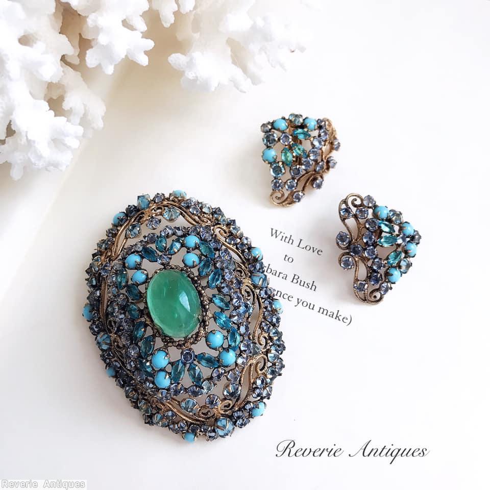 Schreiner highly domed oval shaped pin 1 large oval cab center 8 scrollwork 8 small surrounding navette green large oval cab babyblue opaque chaton goldtone navy blue inverted stone jewelry