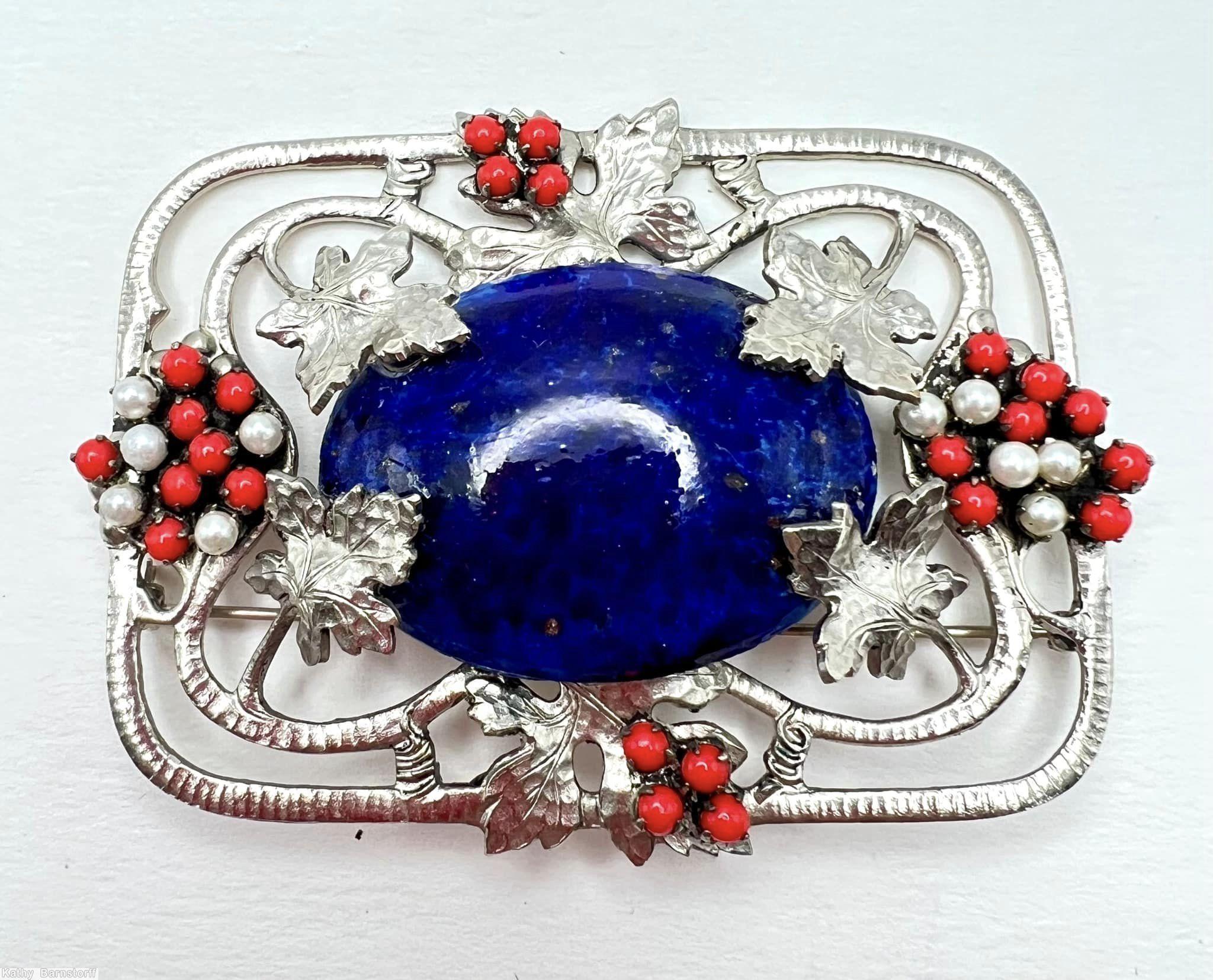 Schreiner rectangle metal deco grape pin 6 molded metal grape leaf covered large oval cab center 2 groups of 4 small round cab 2 groups of 13 small round stone 8 metal wire border with marks large oval lapis cab center red small round cab small faux pearl molded large grape leaf silvertone jewelry