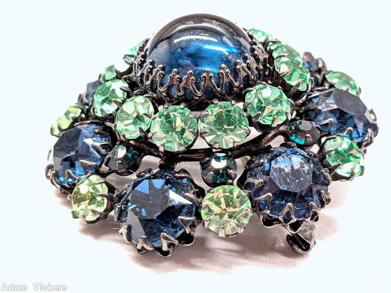 Schreiner round domed pin large round cab center 12 surrounding small chaton 7 large chaton large blue cab center green small chaton blue large chaton silvertone jewelry