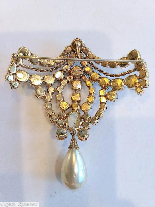 Schreiner top down dangling pin top part bilateral symmetry arc of varied size inverted stone double twisted metal wire 3 stone in a row center one large oval stone large dangling teardrop peridot inverted stone faux pearl large teadrop baroque faux pearl clear champagne faceted large oval stone aqua inverted stone crystal goldtone jewelry