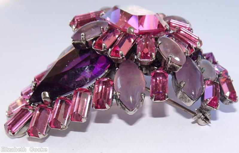 Schreiner triangle shaped 2 level domed radial pin top level large emerald cut center 12 surrounding baguette 4 navette bottom level large teardrop baguette navette wine large emerald cut purple large teardrop wine baguette moonglow lavender navette silvertone jewelry