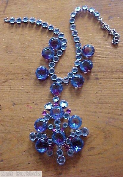 Schreiner single chain of faceted chaton with 7 drippy large faceted chaton dangling radial shield shaped pendant large faceted chaton center 6 large faceted chaton bicolor sapphire ruby ice blue jewelry