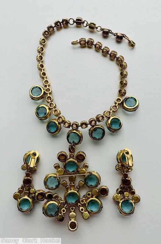 Schreiner single chain of faceted chaton with 7 drippy large faceted chaton dangling radial shield shaped pendant large faceted chaton center 6 large faceted chaton ice aqua large faceted chaton brown inverted small chaton goldtone jewelry